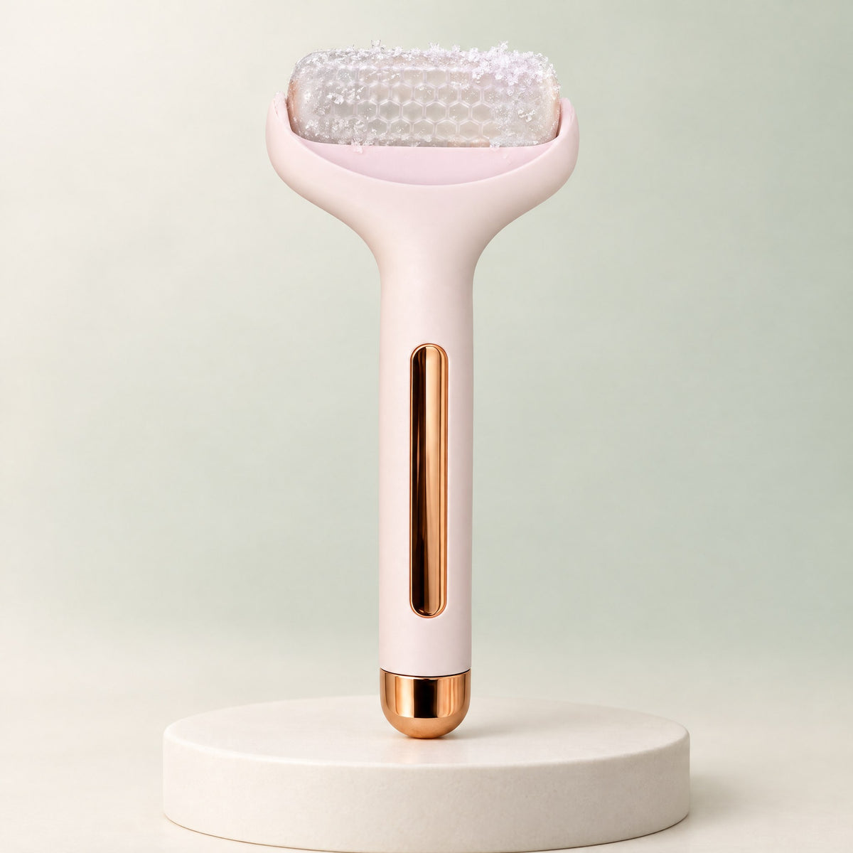 Rodillo de frío facial Escarcha rosa con cabezal transparente, de pie sobre un pedestal