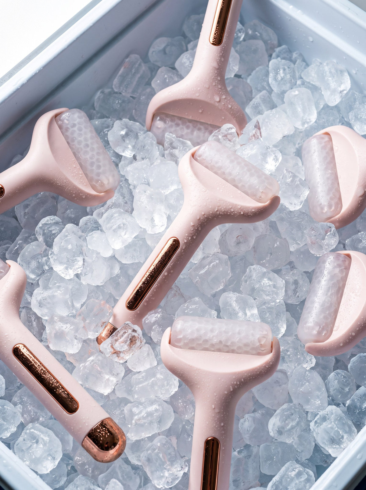 Varios rodillos de frío Escarcha rosa entre cubitos de hielo