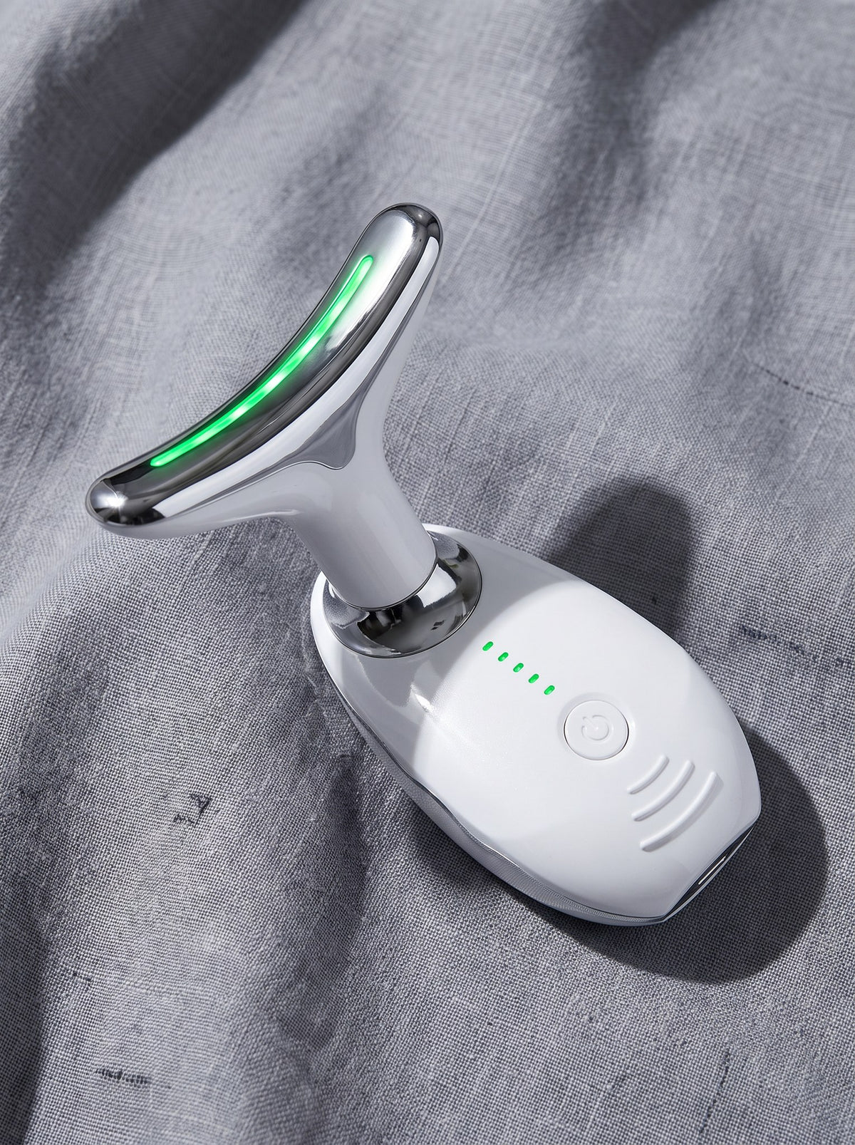 Masajeador de cuello Cisne con luz LED verde, sobre tela de lino gris