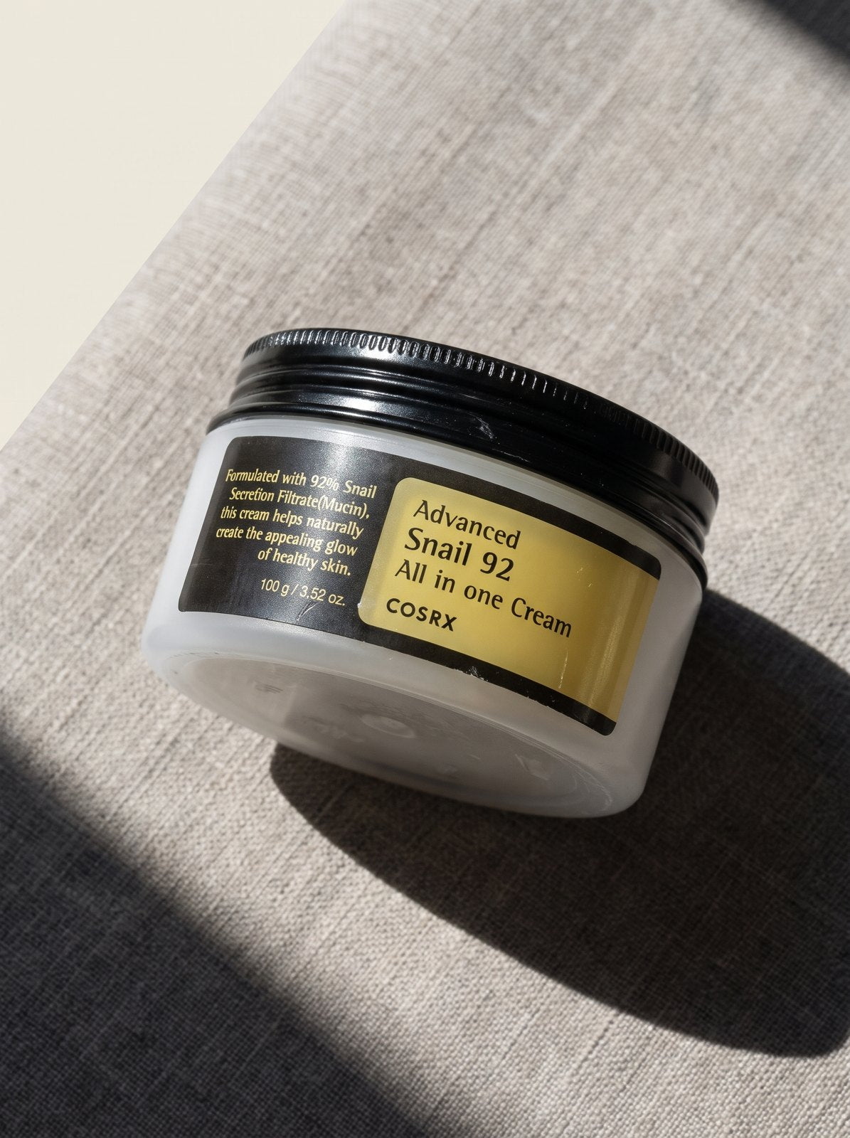 COSRX Advanced Snail 92 Cream sobre lino con luz natural