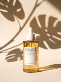 Frasco de SKIN1004 Madagascar Centella Ampoule 100 ml con sombras de hojas
