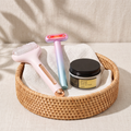 Rodillo facial frío Escarcha, varita Aurora y crema COSRX Advanced Snail 92 en una cesta de ratán