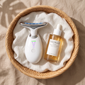 Masajeador facial Contorno y sérum SKIN1004 Centella Ampoule en una cesta de ratán con lino